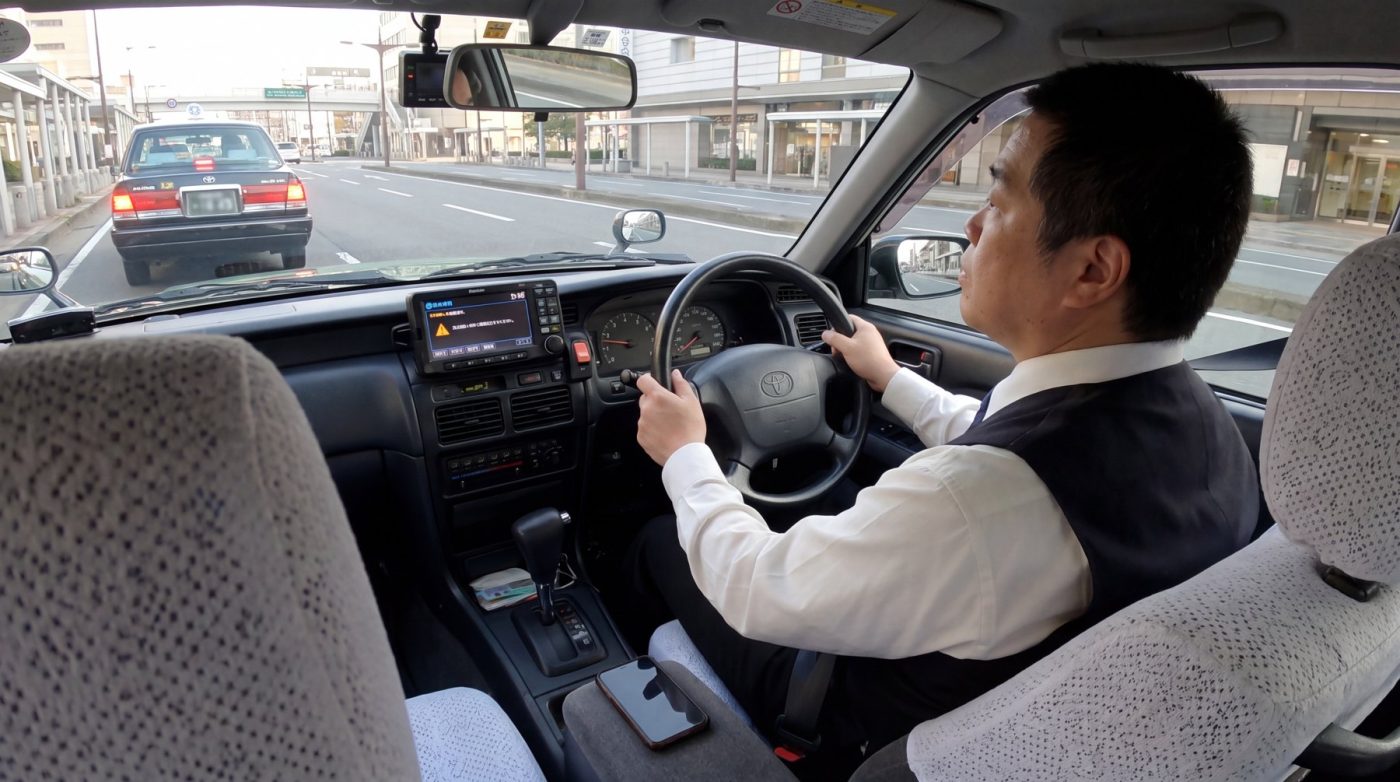 ハンドルを前に座る運転席の後ろ姿（創作事例のイメージ）