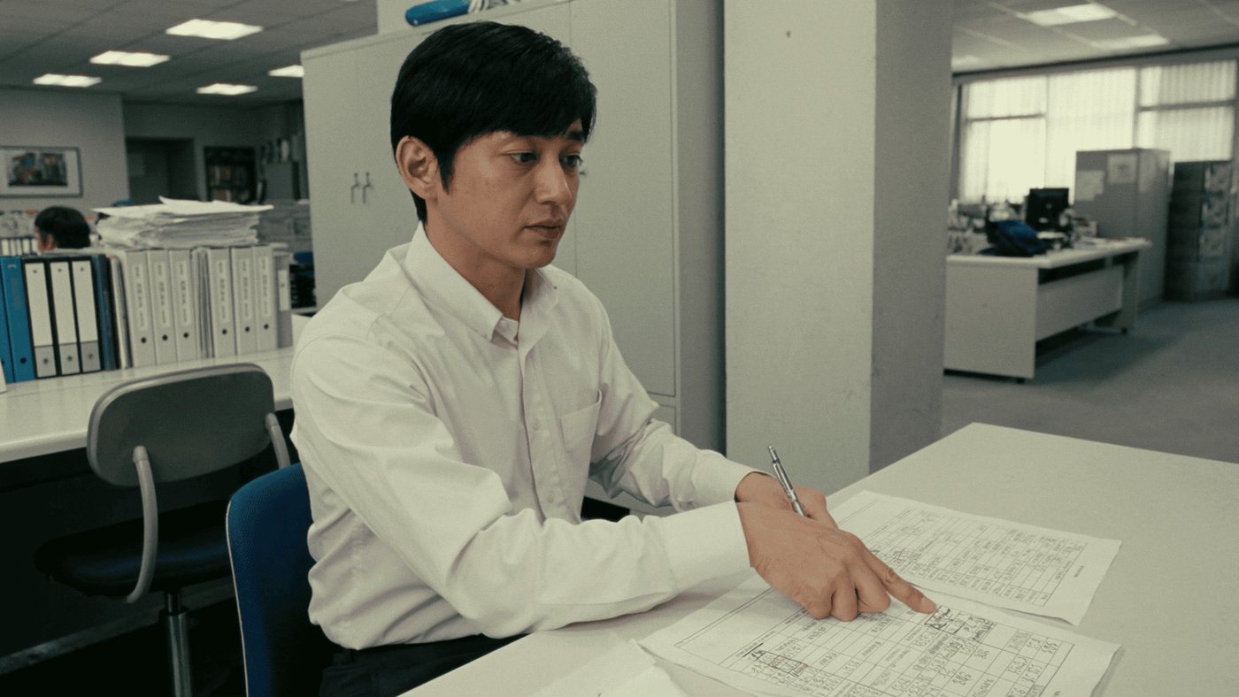 事務所で点検報告書を確認する様子（創作事例のイメージ）