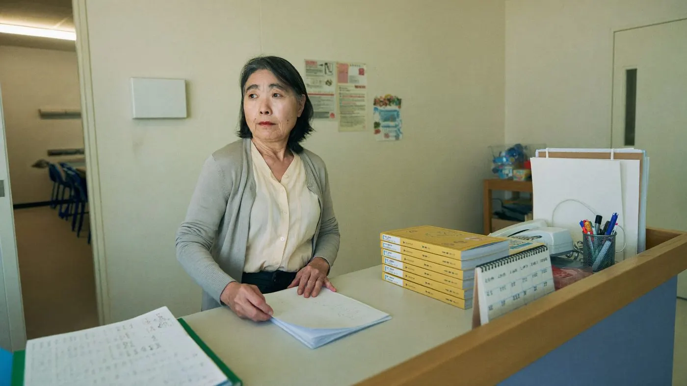 学習塾の受付で事務の仕事をする様子（創作事例のイメージ）